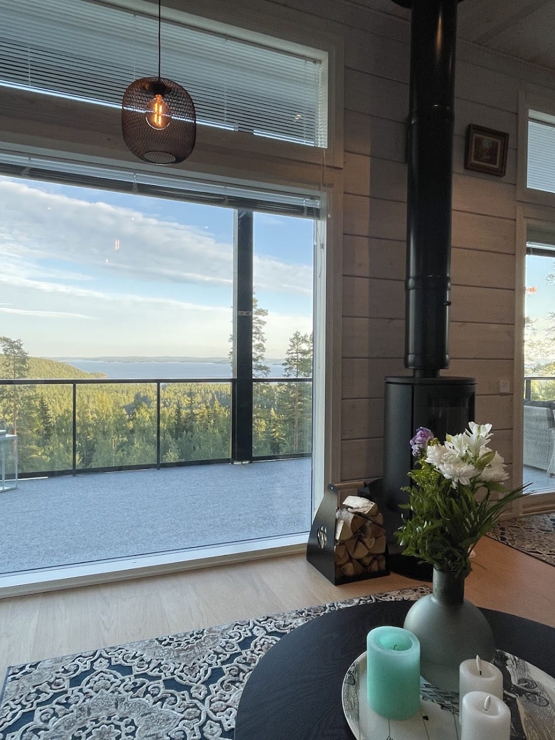 Olohuone takkoineen, järvimaisema suurista ikkunoista
