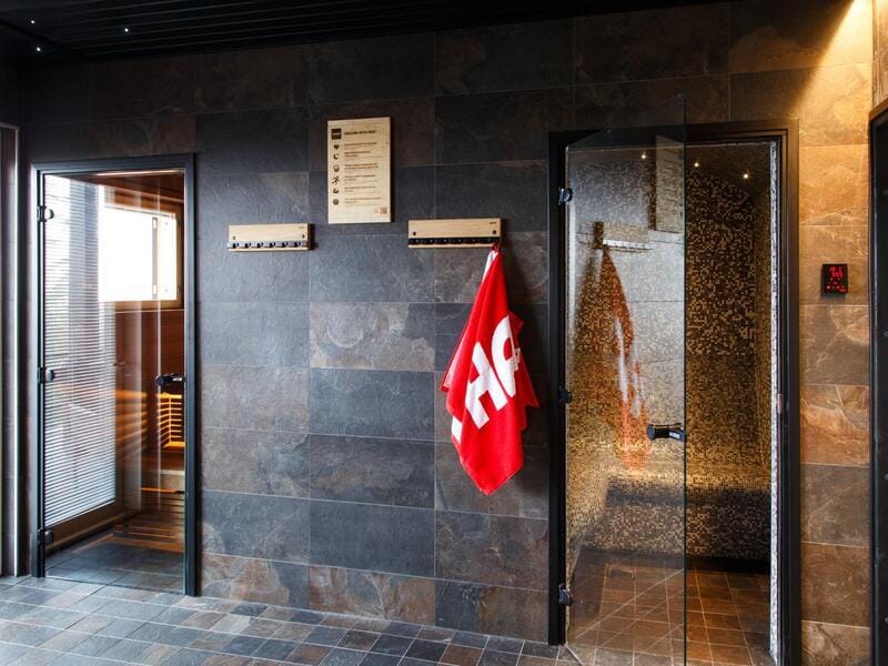 SPA-käytävä liuskekivilaatoin, saunojen ovet rivissä