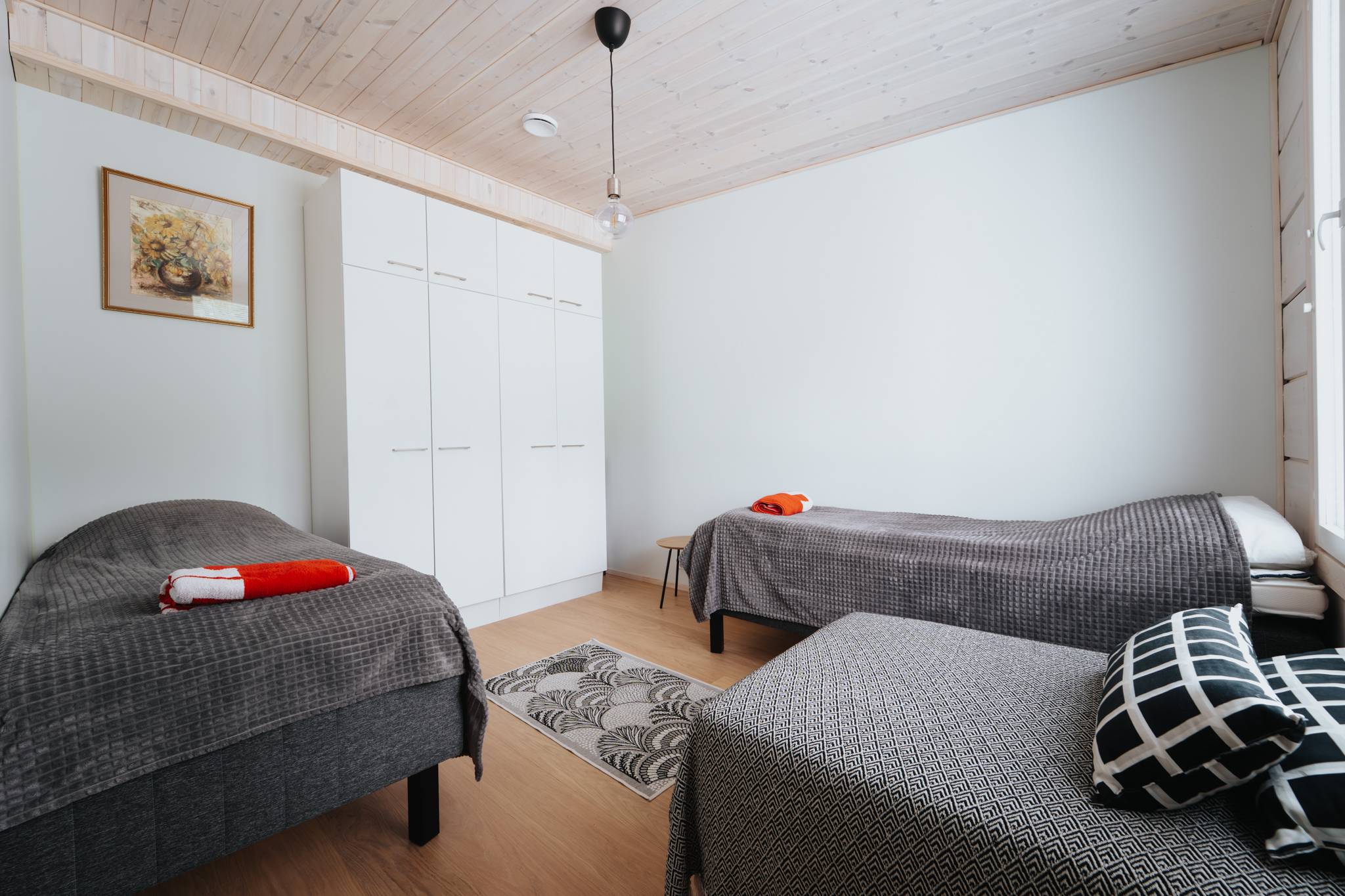 Karhu A spa vuokramökki – lasiseinäinen olohuone ja järvimaisema