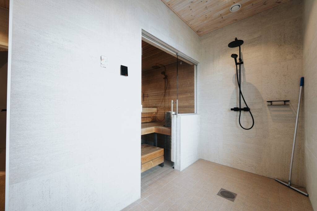 Karhu A spa vuokramökki – lasiseinäinen olohuone ja järvimaisema
