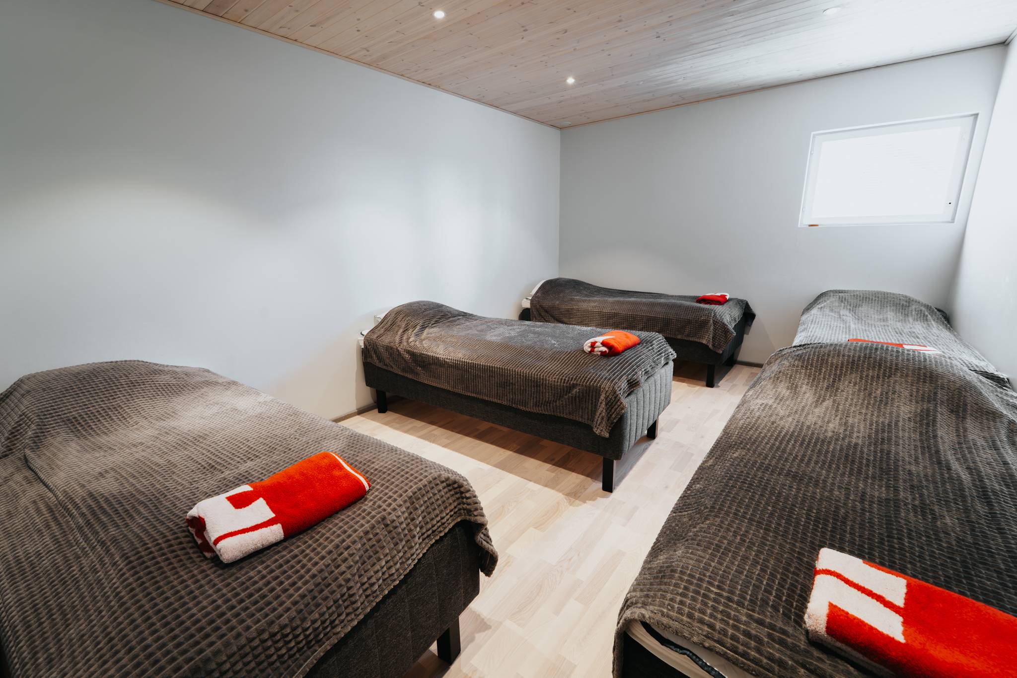 Karhu A spa vuokramökki – lasiseinäinen olohuone ja järvimaisema