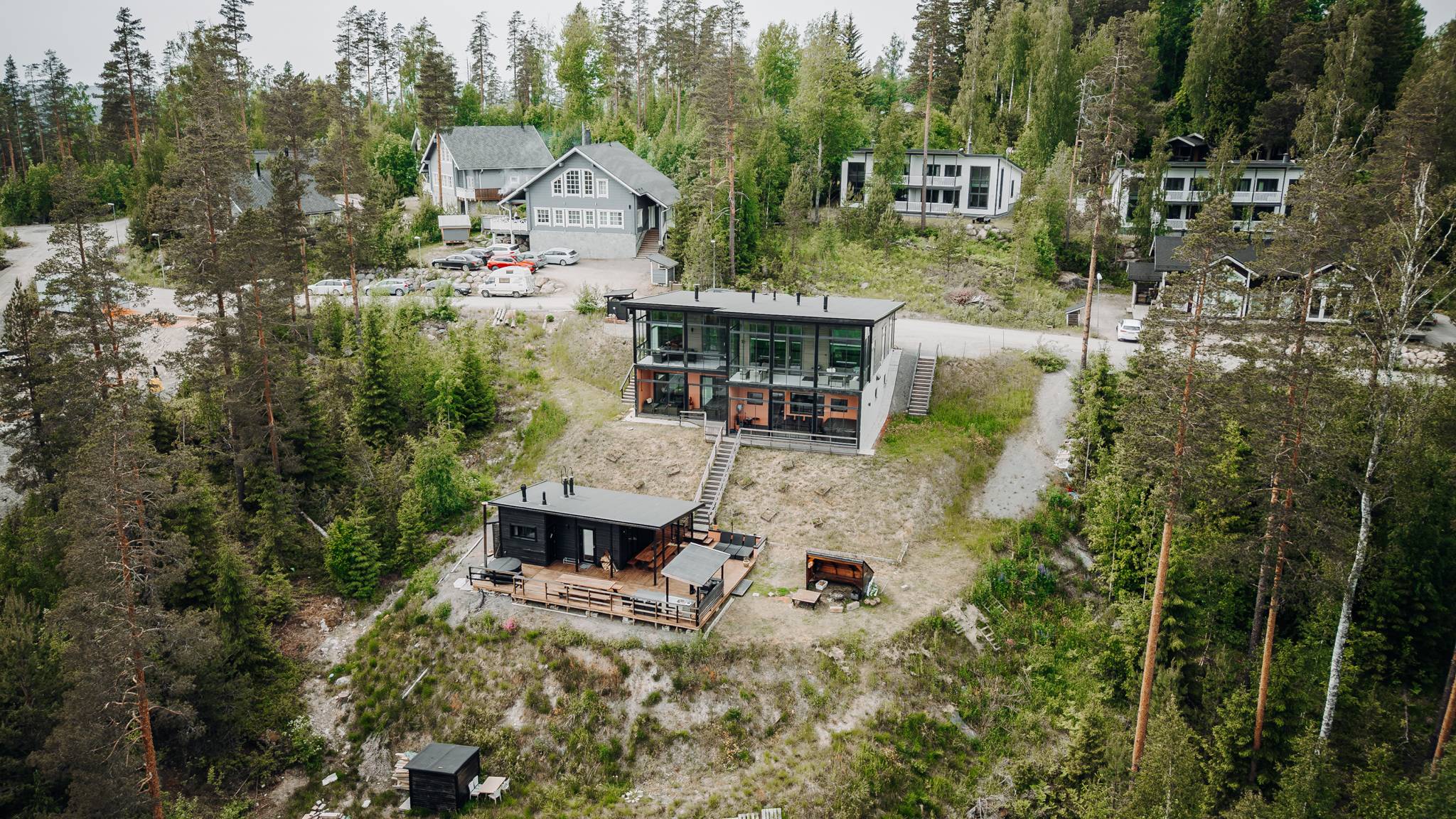 Karhu A spa vuokramökki – lasiseinäinen olohuone ja järvimaisema